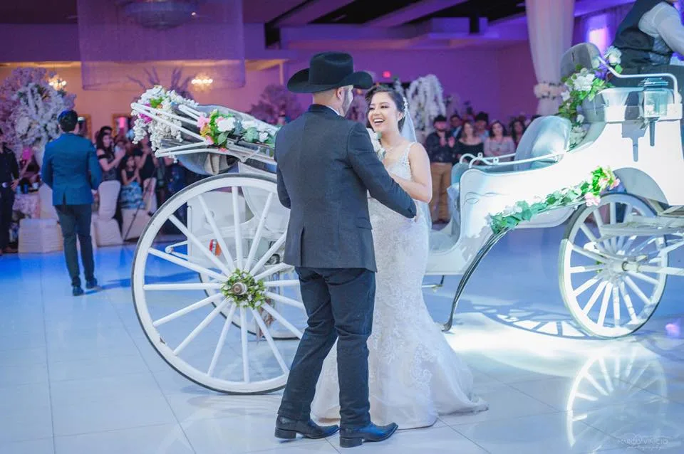 Bride and groom beside the horse-drawn carriage at Legends Event Center